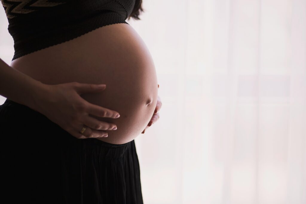 a pregnant woman holding her bump 